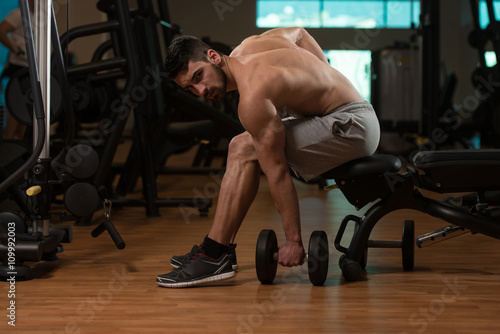 Man In The Gym Exercising Biceps With Dumbbell