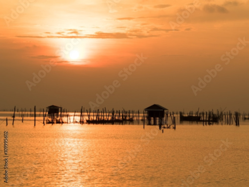 Blurred beautiful sunset above the sea in thailand. Silhouette of fish farms at sunset. © ieang