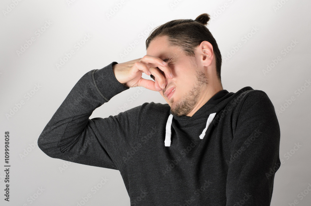 Man holding his nose against a bad smell Man holding his nose against a bad smell