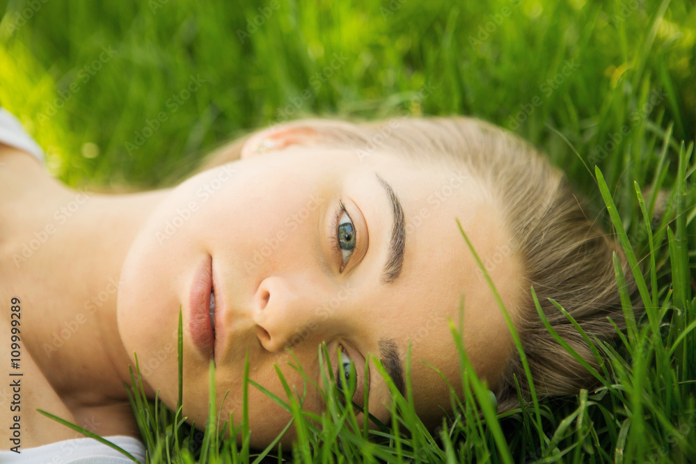 portrait of the young beautiful woman of the vacationer on a grass in park portrait of the young beautiful woman of the vacationer on a grass in park
