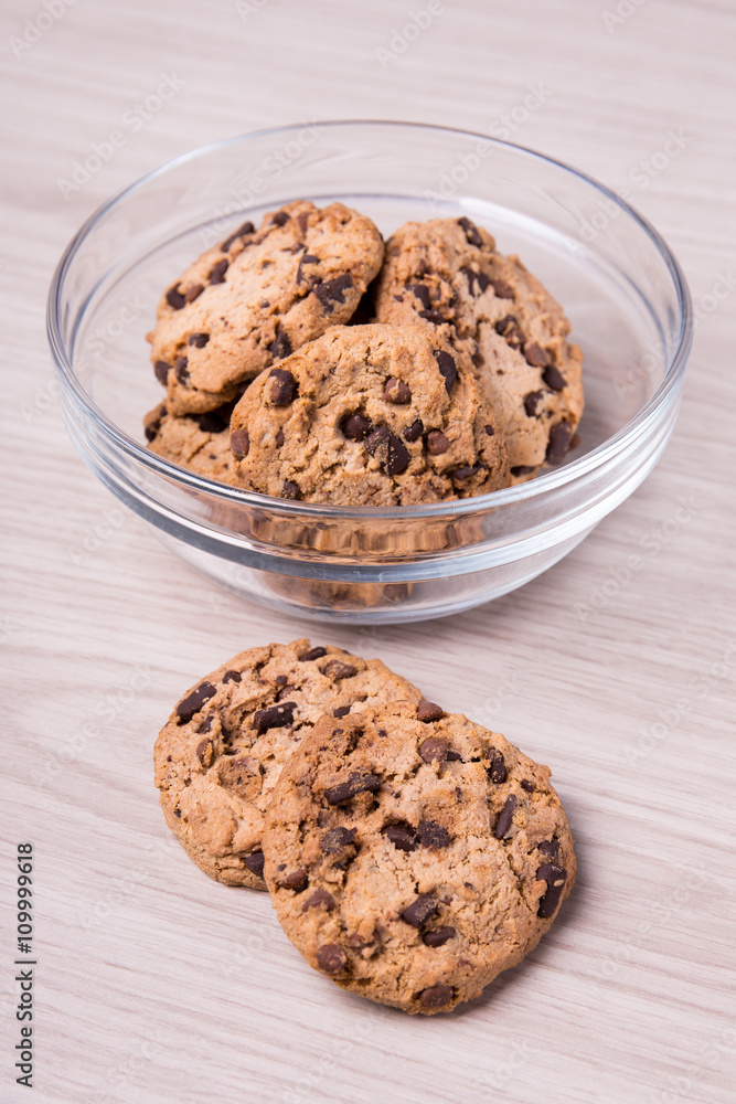 chocolate chip cookies in glass bowl on wooden background chocolate chip cookies in glass bowl on wooden background