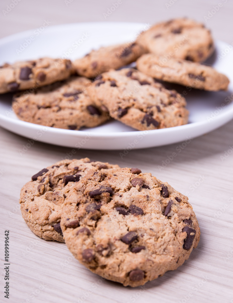 close up of chocolate chip cookies on wooden background close up of chocolate chip cookies on wooden background