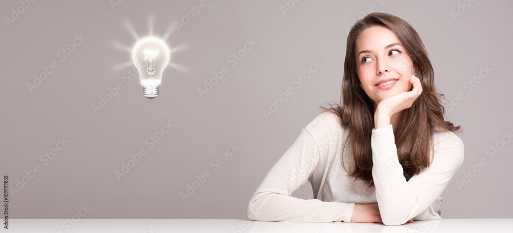Fototapeta premium Young woman next to creativity symbol.
