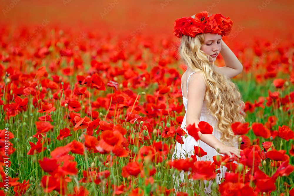 Naklejka premium Beautiful girl in a red flowers field 