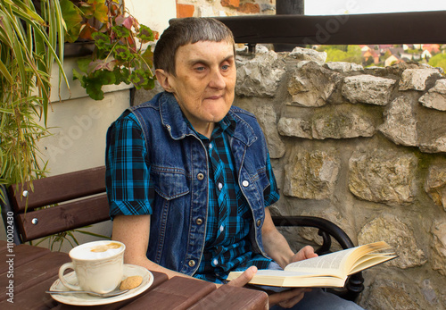 A man with cerebral palsy reading a book.