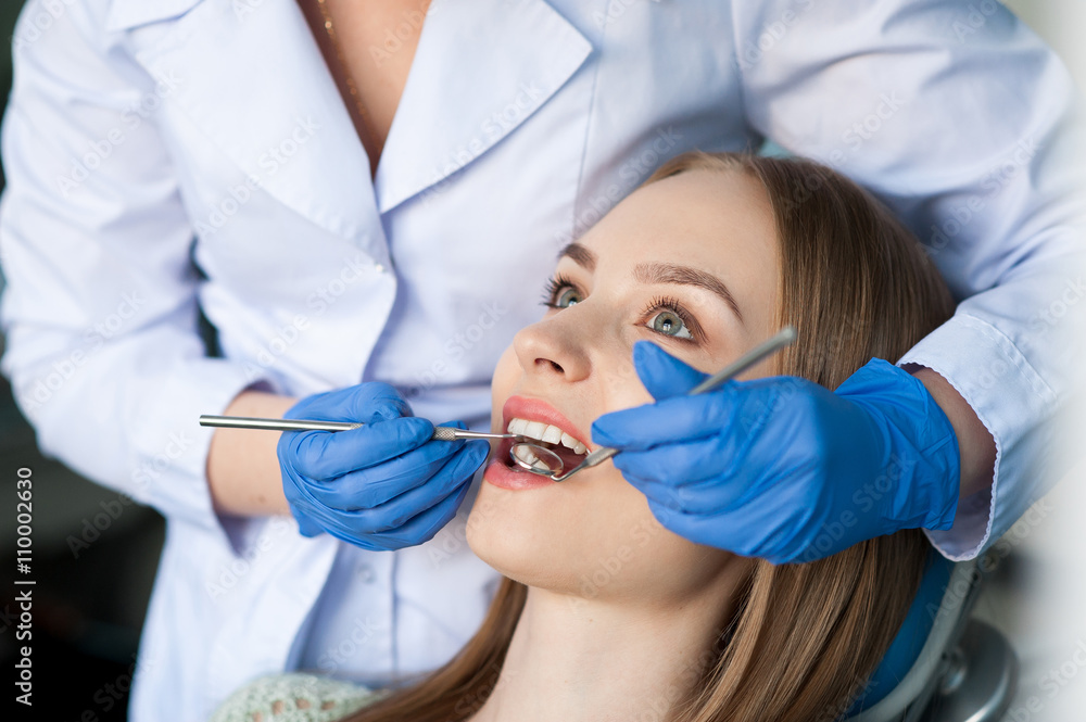 Dentist examining a patient's teeth Dentist examining a patient's teeth