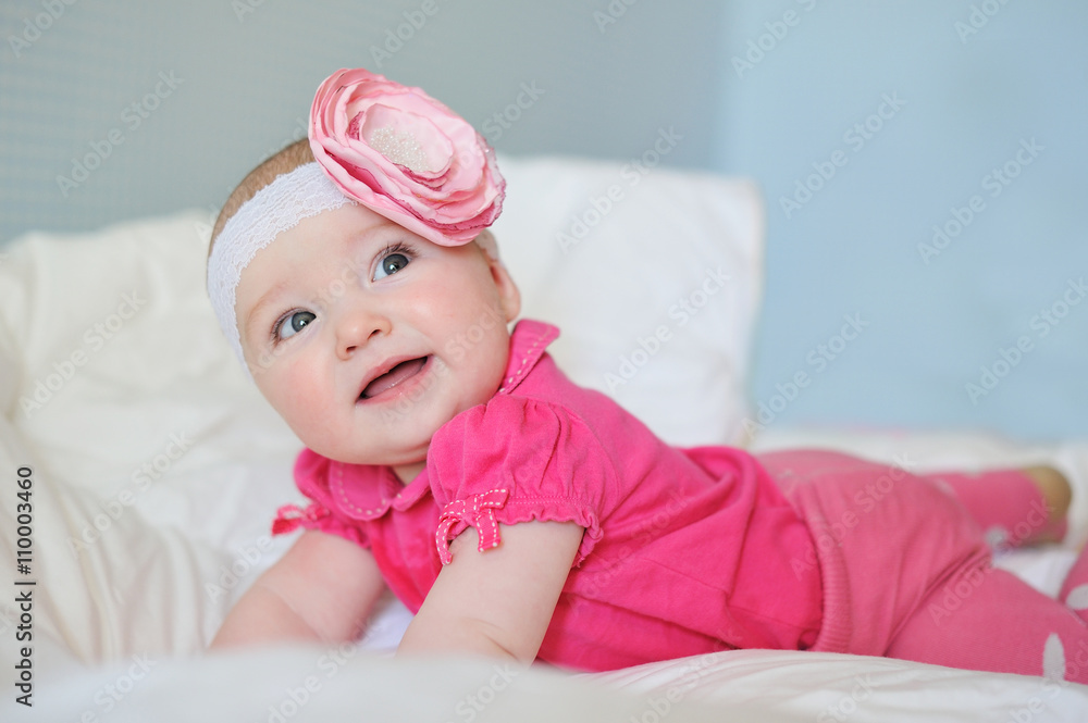 Amazed cute little baby with chubby cheeks wearing pink clothes and band flower Amazed cute little baby with chubby cheeks wearing pink clothes and band flower