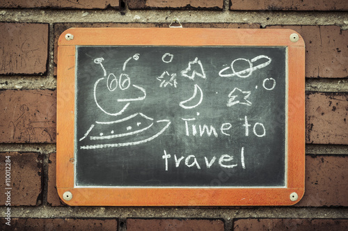 Tafel an einer Ziegelwand mit Text / Tafel an einer Ziegelwand mit Text Time to travel. © ub-foto