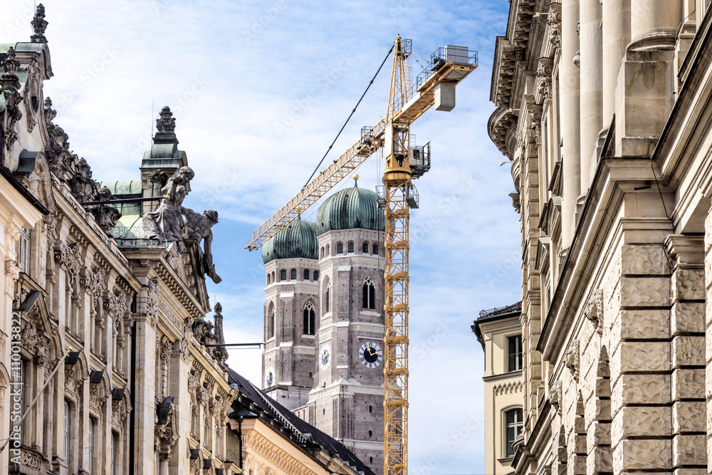 Fototapeta premium München: Häuser Fassaden mit Kran und Frauenkirche im Hintergrund