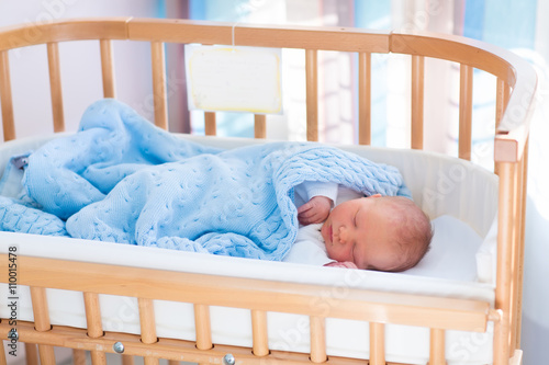 Newborn baby boy in hospital cot photo