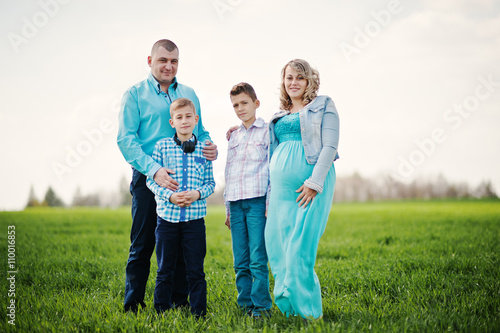Happy pregnant family with two sons, dressed in a turquoise clot © AS Photo Family