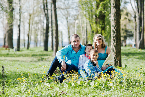 Happy pregnant family with two sons, dressed in a turquoise clot