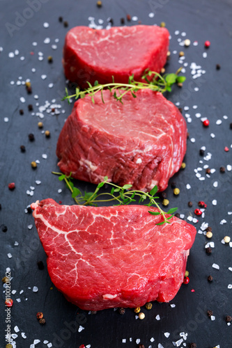 Fresh Raw Beef steak Mignon, with salt, peppercorns, thyme, garlic.