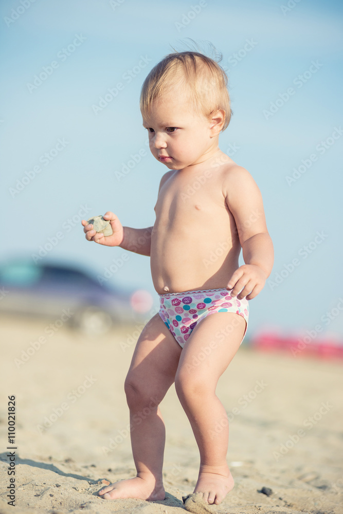 Baby playing with toys on the sandy beach near the sea. Cute little kid in sand on tropical beach. Ocean coast. Baby playing with toys on the sandy beach near the sea. Cute little kid in sand on tropical beach. Ocean coast.