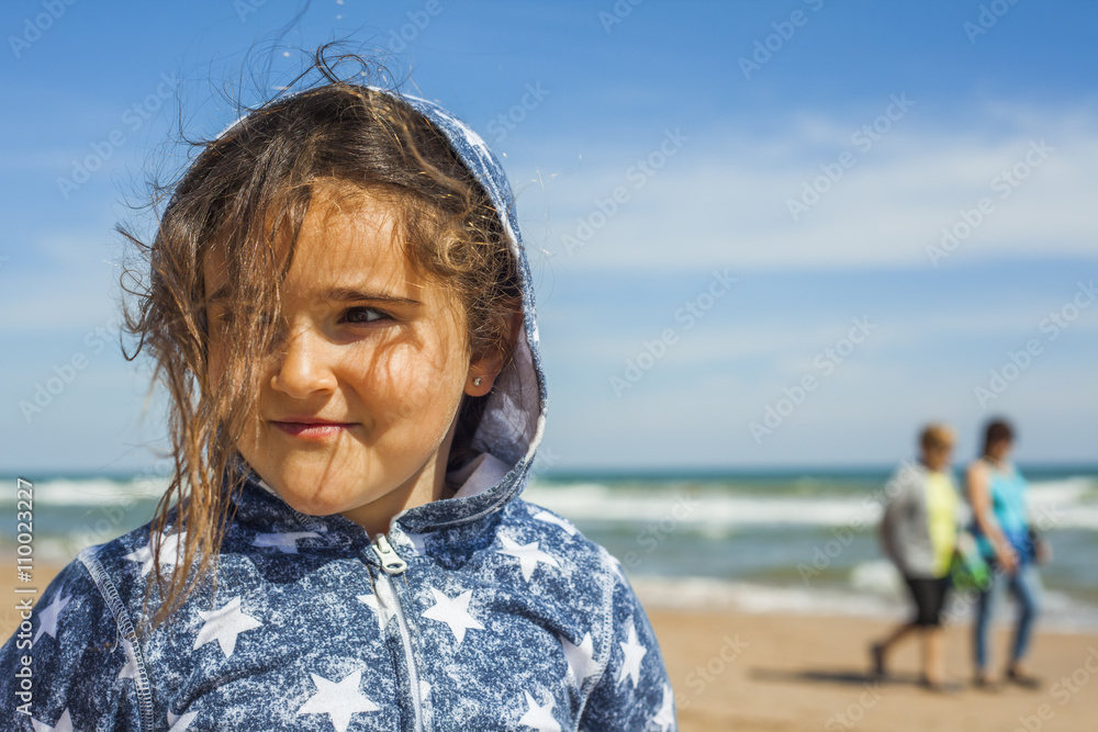 Close up smily girl posing in the beach in a windy day in Easter Close up smily girl posing in the beach in a windy day in Easter