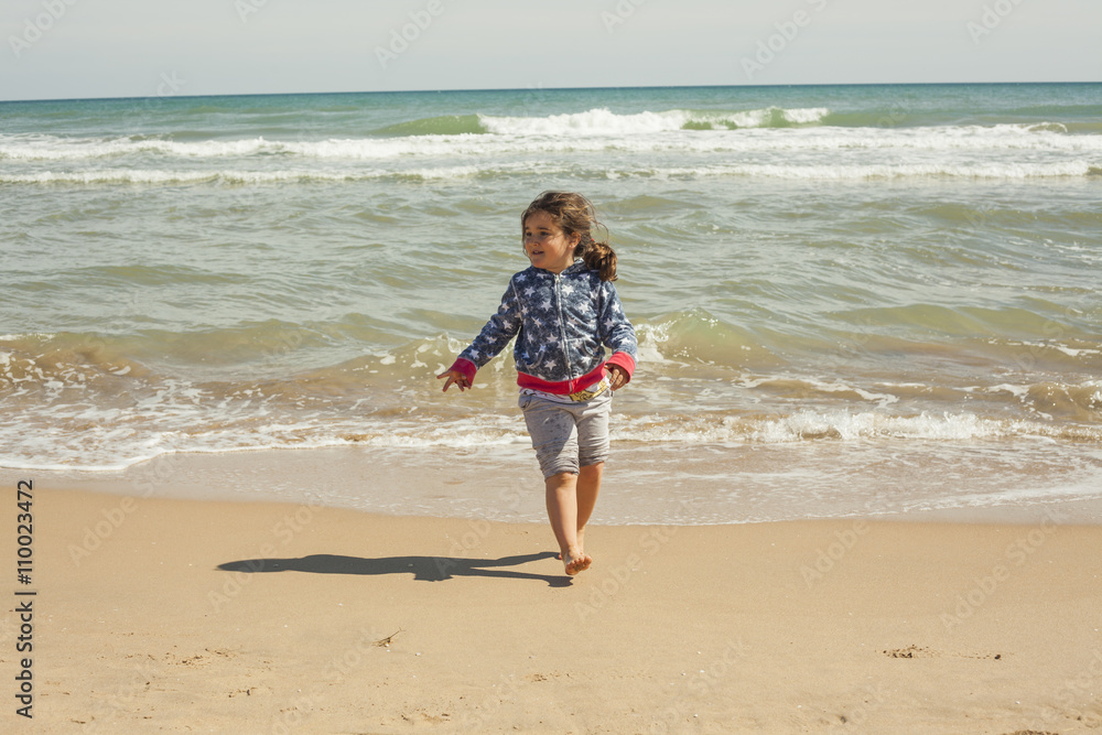 Full shot girl running in the shore of the beach in a sunny day Full shot girl running in the shore of the beach in a sunny day