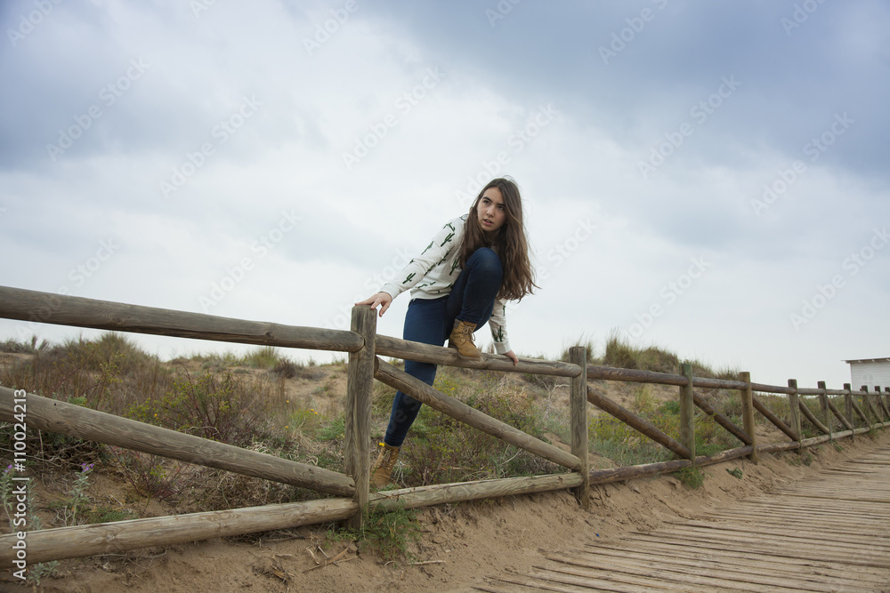 Full shot happy teenager standing up in a wood handrail ready to