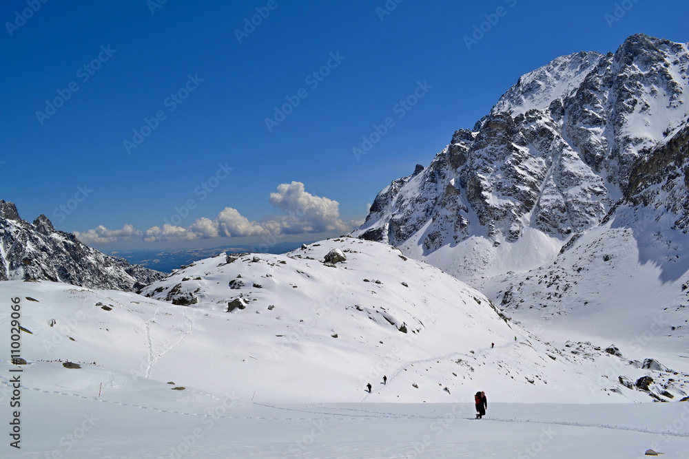 Hiking trail in snow in mountains in a sunny day