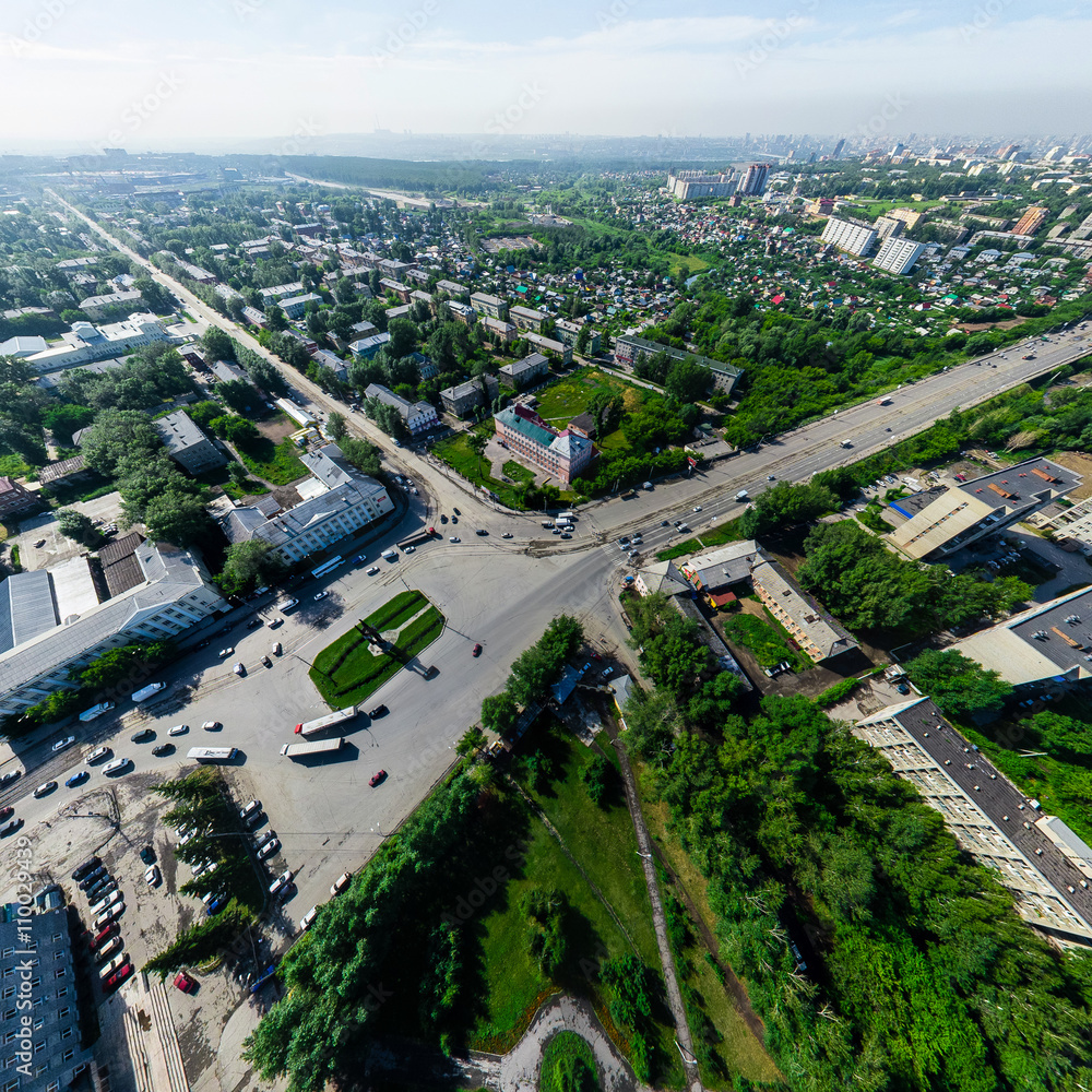 Aerial city view with crossroads and roads, houses, buildings, parks and parking lots, bridges. Copter shot. Panoramic image.