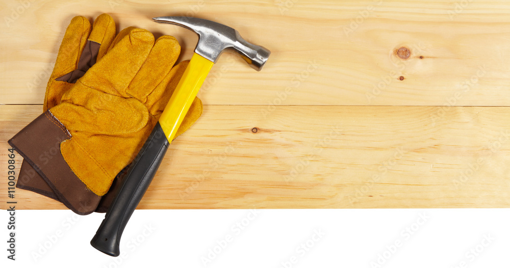 Hammer and gloves wrench on wooden background