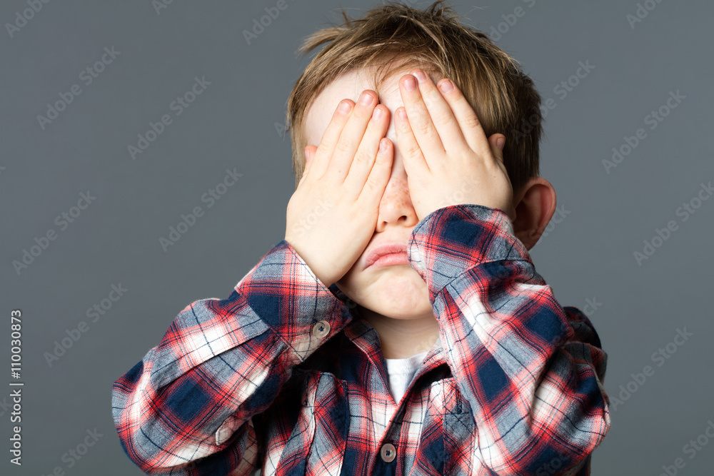 unhappy young child covering his eyes with hands for sadness unhappy young child covering his eyes with hands for sadness