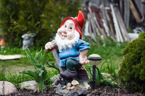 Statue of gnome with red hat in garden