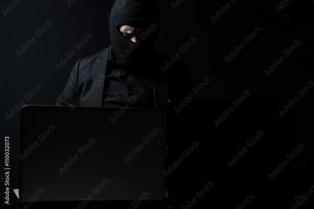 Angry business man as computer hacker in suit stealing data from Angry business man as computer hacker in suit stealing data from