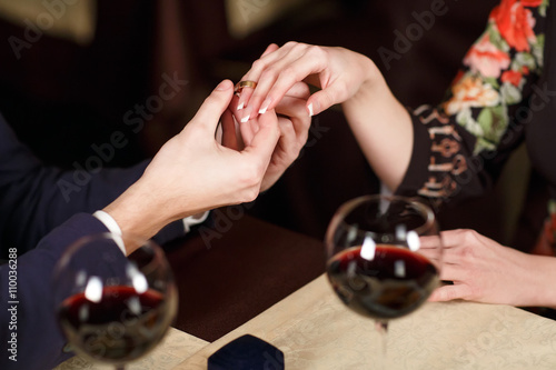 Young Man puts the ring on the finger of his girlfriend.