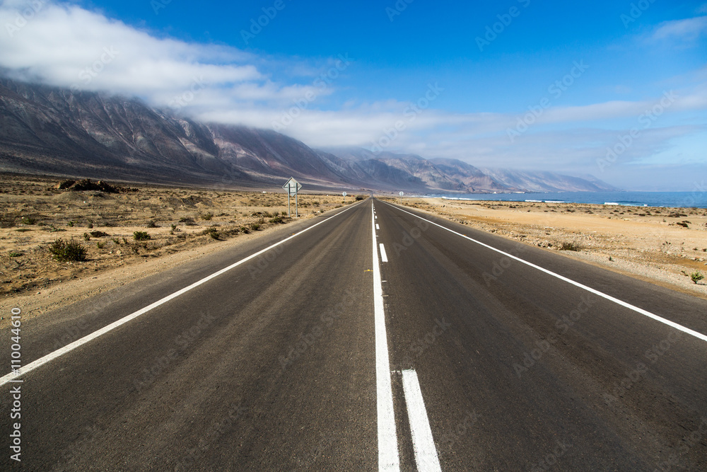 Beautiful empty road in a blue sky day - northern of Chile.
