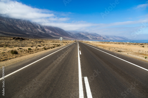 Beautiful empty road in a blue sky day - northern of Chile. photo