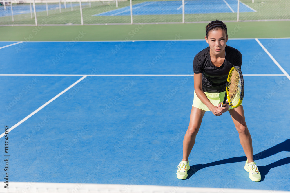 Asian tennis player woman ready to play on blue hard court outdoor in summer in position holding racket wearing outfit with skirt and shoes. Female athlete determination and concentration concept.