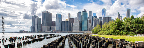 New York City NYC Manhattan island skyline panorama scenic view. Banner crop of waterfront lifestyle for advertisement copyspace. Downtown cityscape from the Brooklyn bridge park Pier 1 salt marsh. 