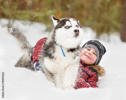 Fototapeta Naklejka Na Ścianę i Meble -  young boy playing with the dog in the snow