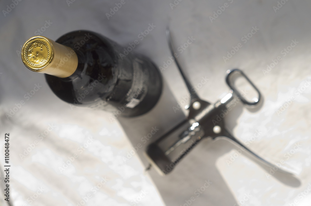 A bottle of wine and a sommelier corkscrew A bottle of wine and a sommelier corkscrew