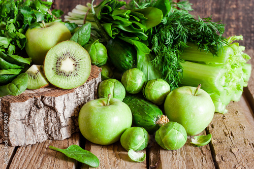 green organic fruit and vegetables on a wooden background