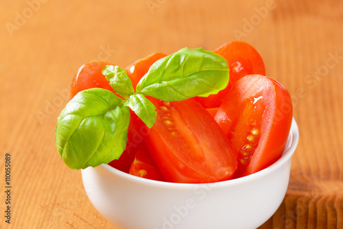 Bowl of halved red plum tomatoes