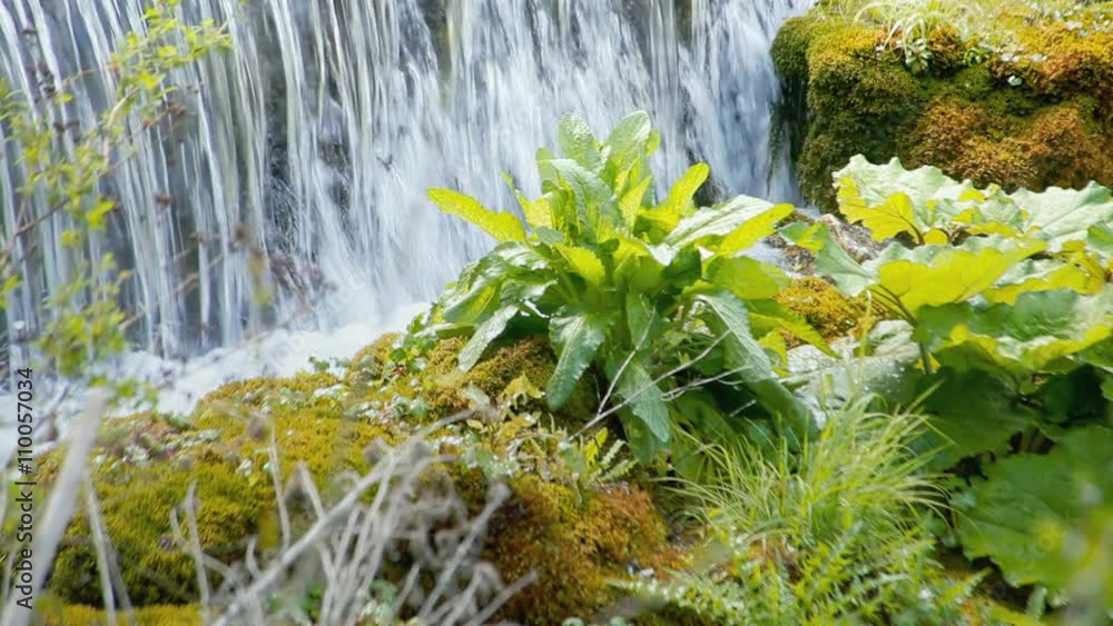 A romantic peaceful view of a waterfall in daylight. Intense colors. A romantic peaceful view of a waterfall in daylight. Intense colors.