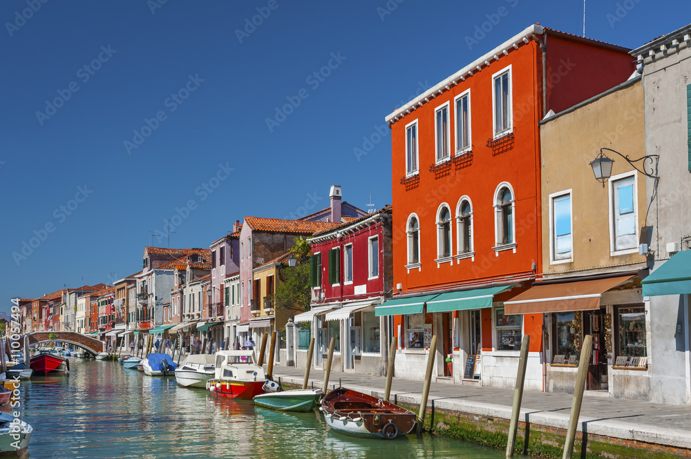 Murano island canal, colorful houses and boats, Venice, Italy.