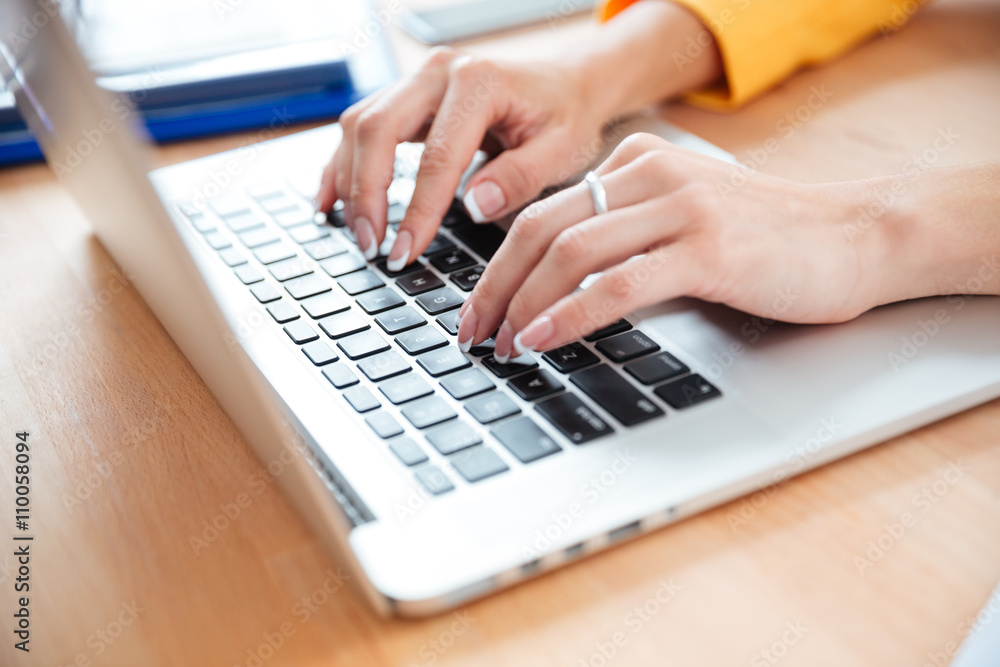 Female hands typing on the laptop computer in office Female hands typing on the laptop computer in office