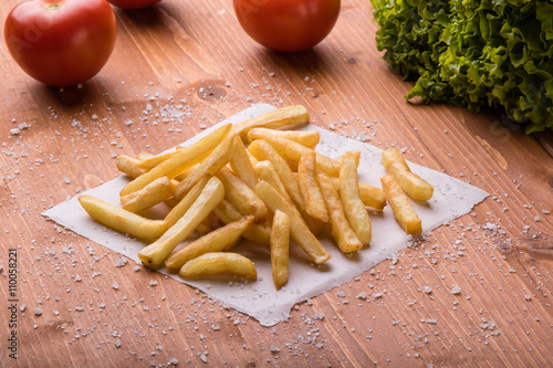 fries on a wooden table with sea salt