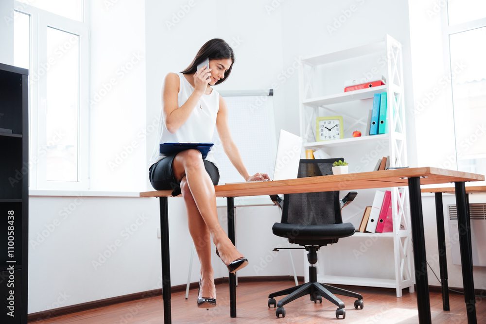 Businesswoman working with phone and laptop computer in office Businesswoman working with phone and laptop computer in office
