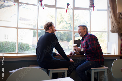 Bild auf Leinwand Two Male Friends Meeting In Coffee Shop