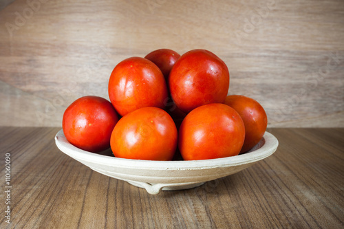 Close-up fresh ripe tomatoes on wood background