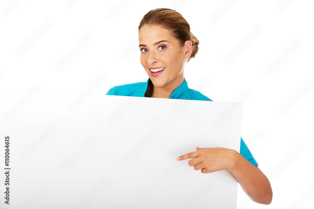 Young female doctor or nurse holding empty banner Young female doctor or nurse holding empty banner
