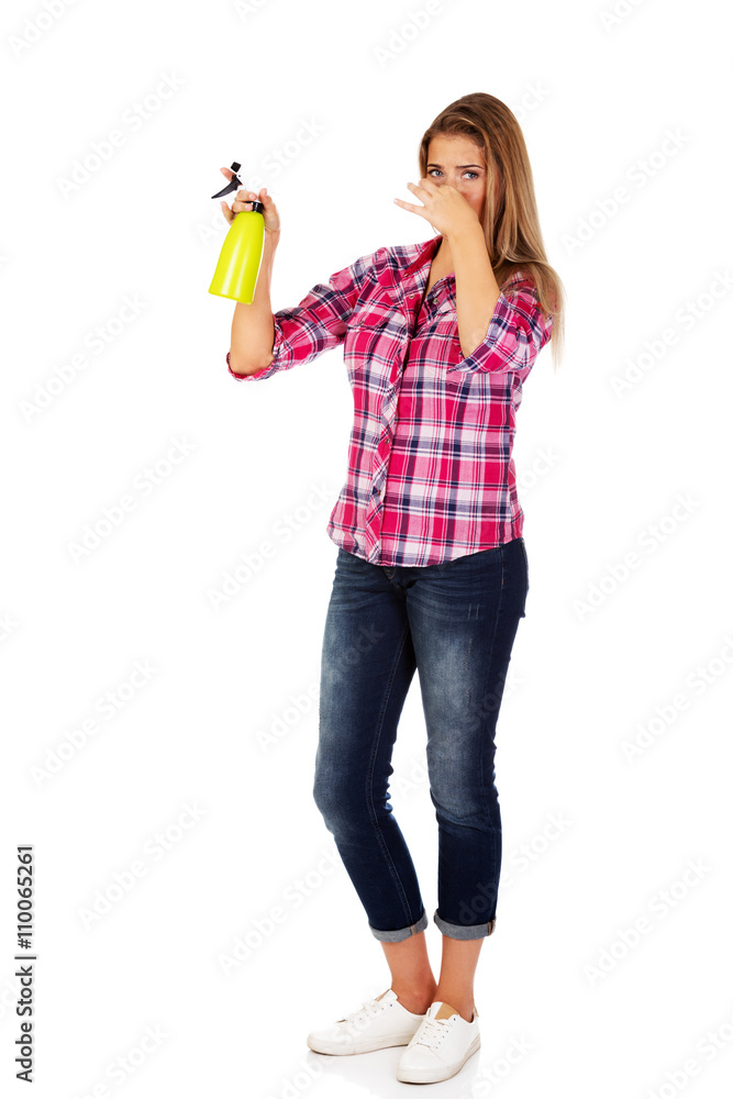 Young woman holding a watering spray bottle Young woman holding a watering spray bottle