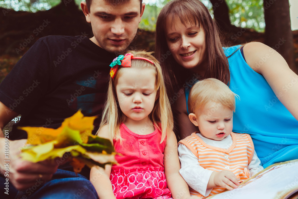 Naklejka premium Young parents read a children's book for kids