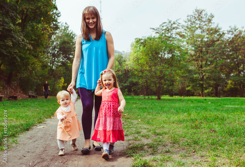 Obraz premium Happy mom is walking with her daughters