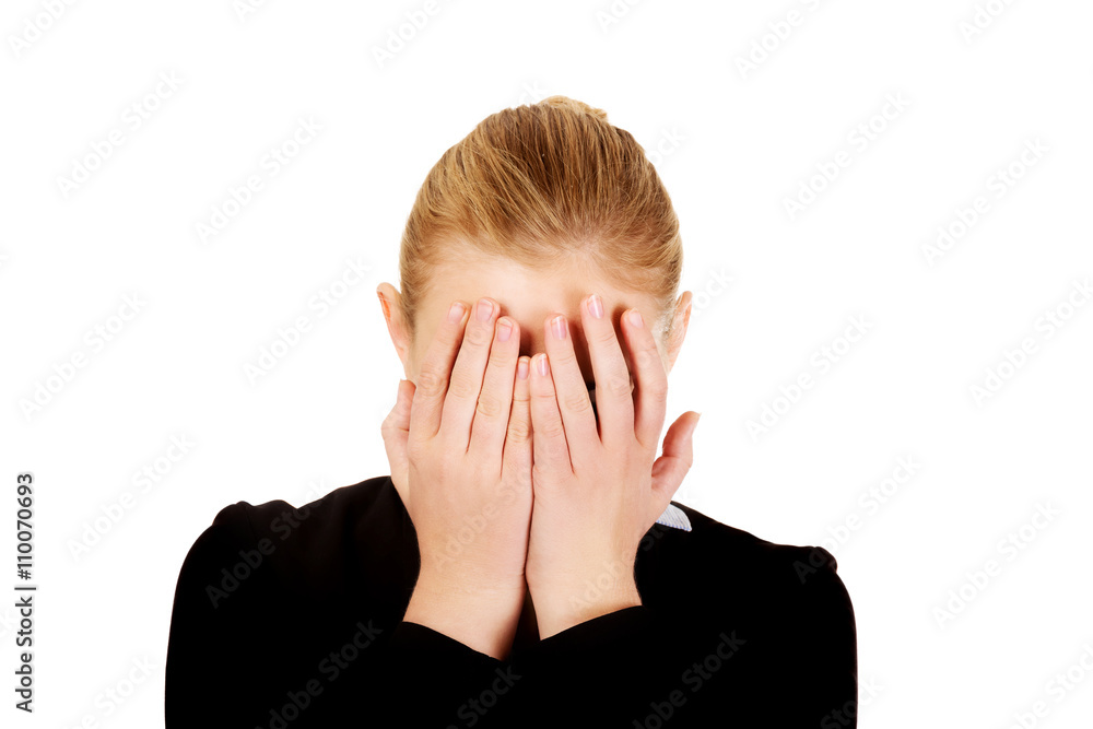 Troubled business woman covering her face with hands Troubled business woman covering her face with hands