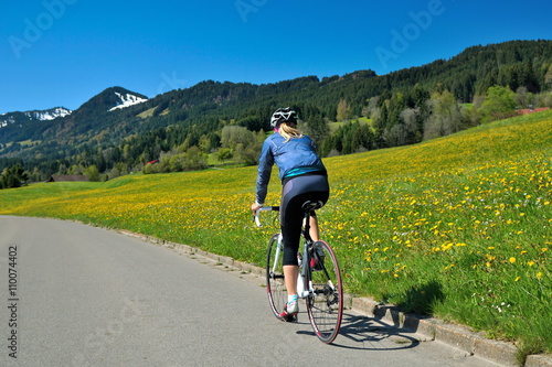 Frau unterwegs mit Rennrad auf Landstrasse