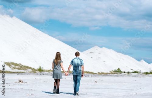 Walk of young couple on the desert earth.